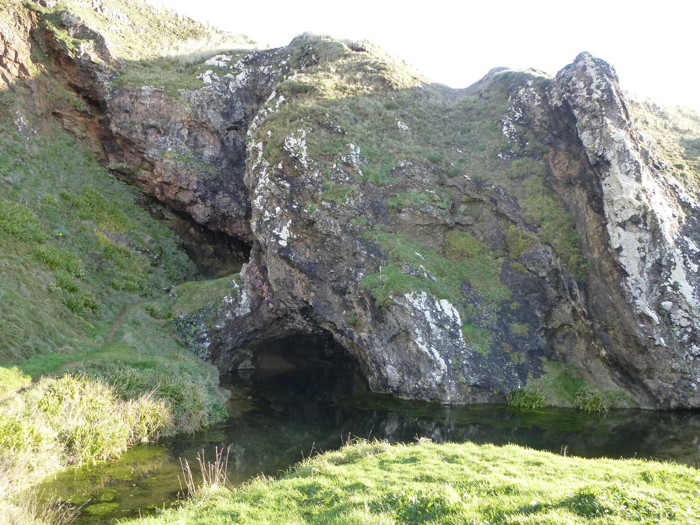 A view of the tide halfway up a sunken cave in a cliff